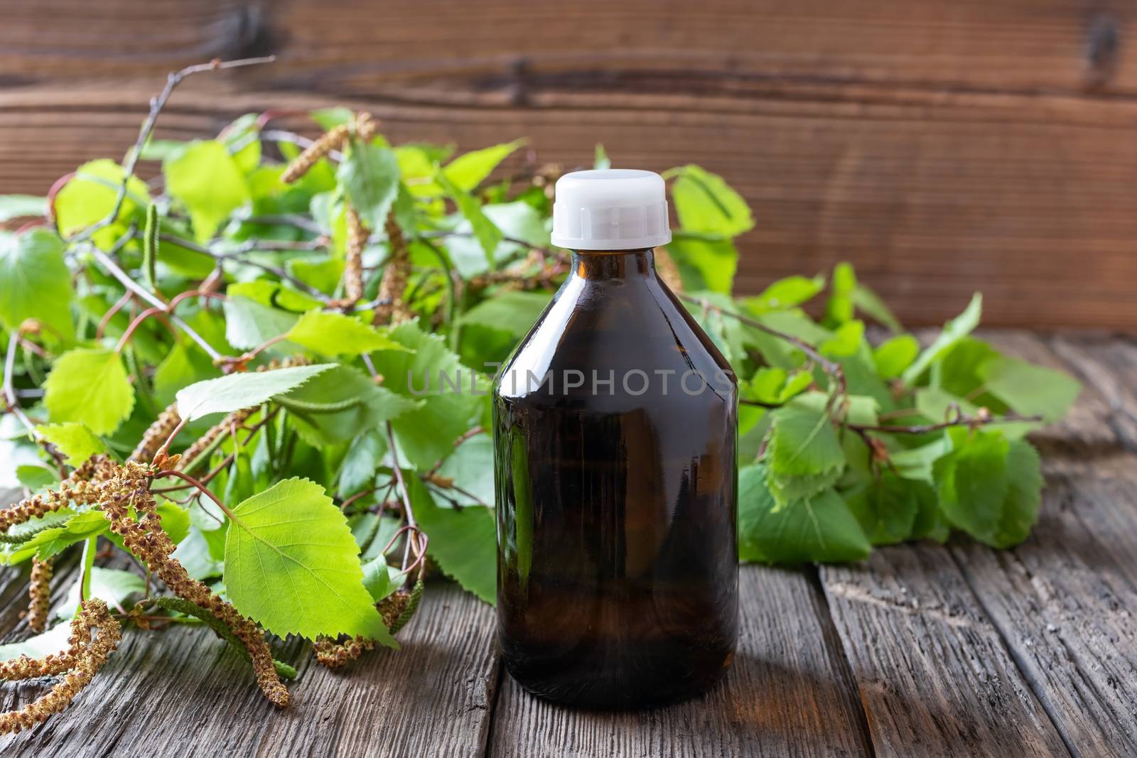 A bottle of tincture with young birch leaves and catkins