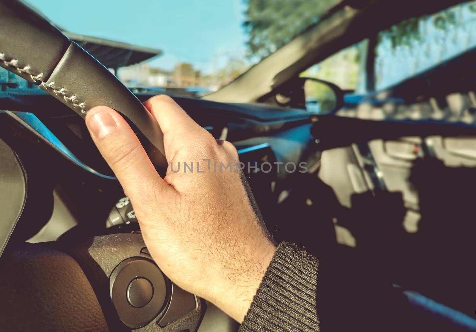 driving learning right hand on steering wheel inside a car with left-hand traffic morning light .