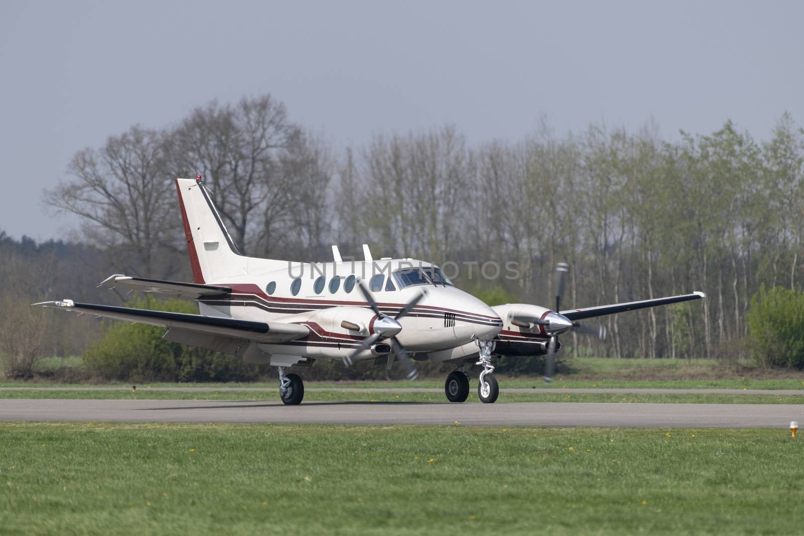 Twin-engined propeller business plane during landing at a small airport
