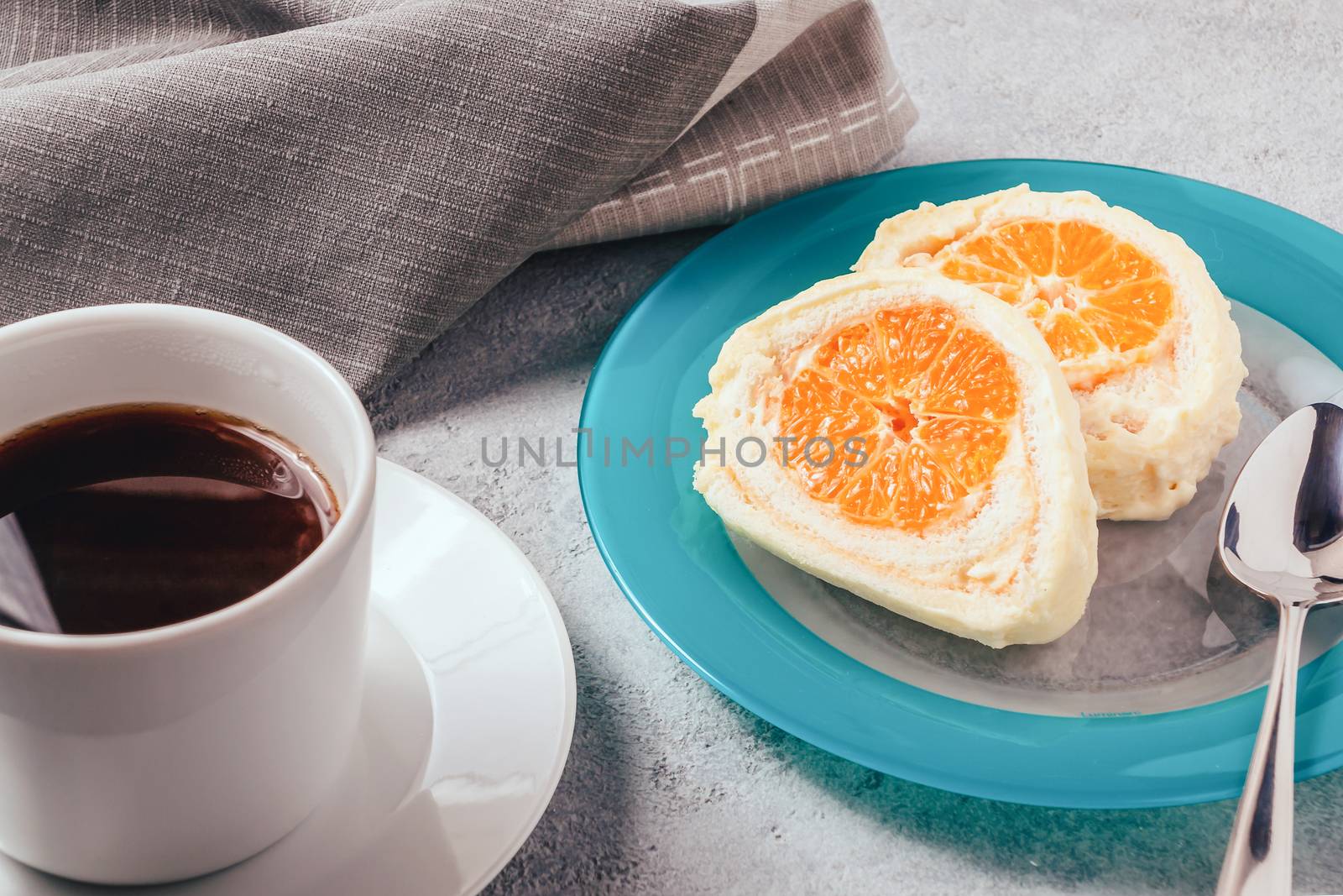 Sweet roll with whipped cream and tangerine filling and a cup of coffee by galsand