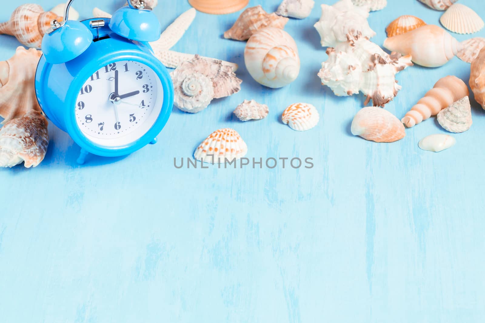 Blue sea background with alarm clocks and seashells, summer holiday and vacation time concept.
