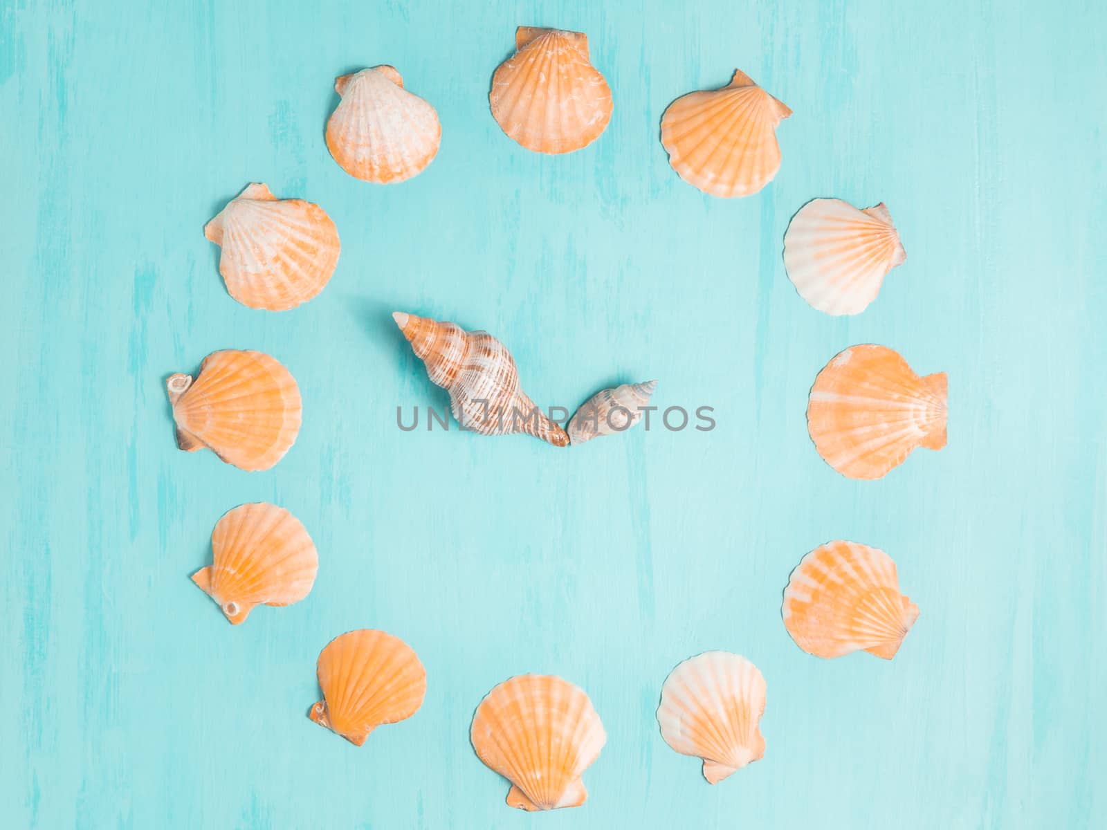 Blue sea background with clocks from seashells, summer holiday and vacation time concept.