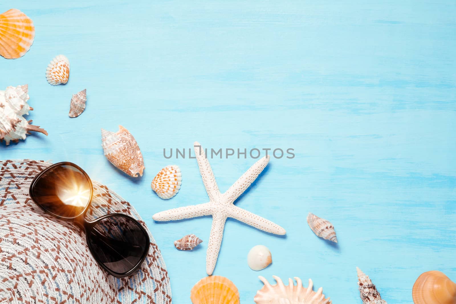 Blue sea background with hat, sunglasses and seashells, summer holiday and vacation time concept by galsand