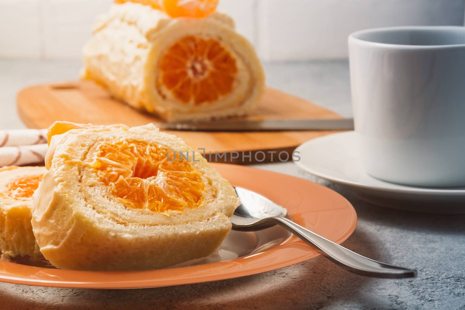 Sweet roll with whipped cream and tangerine filling and a cup of coffee by galsand