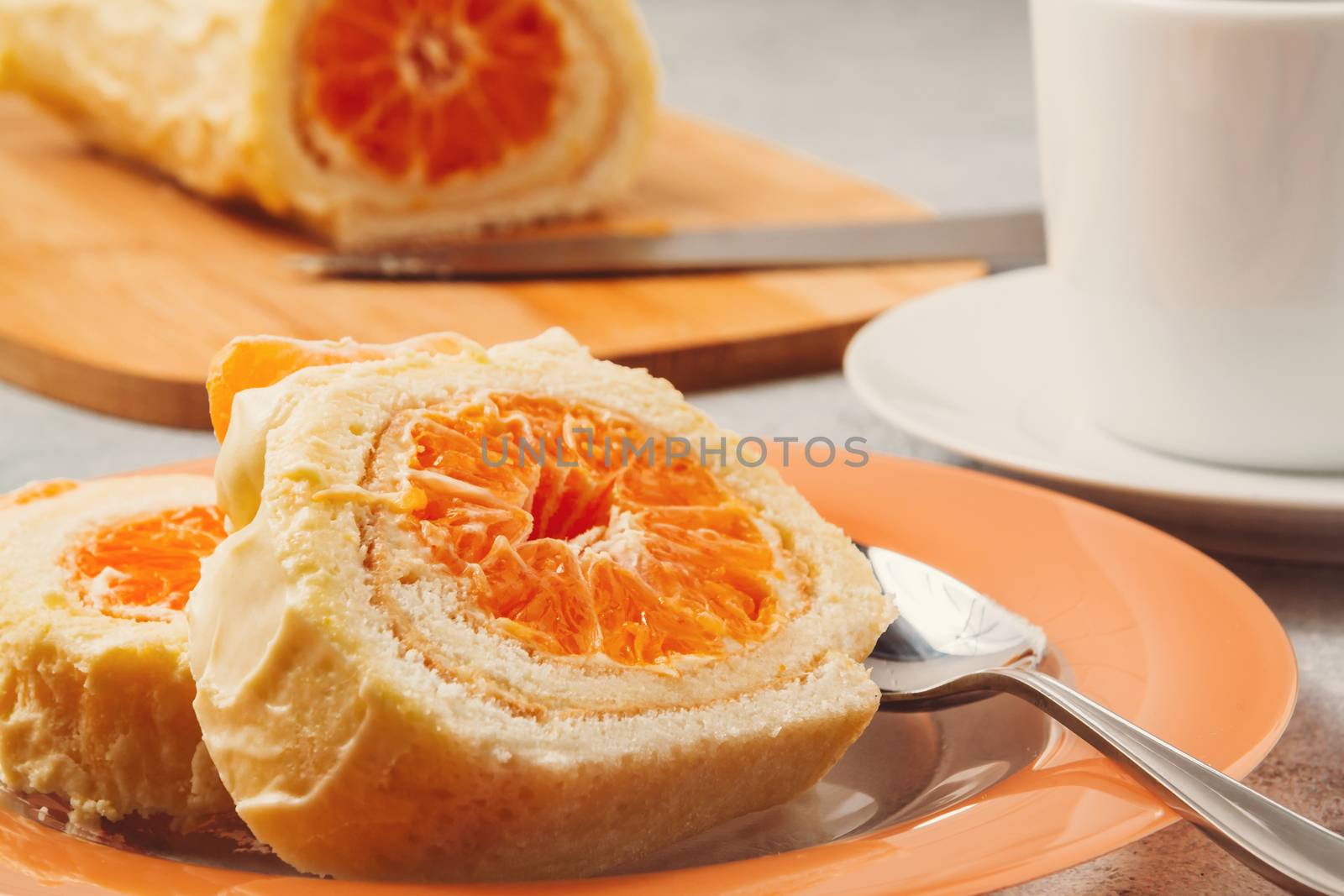 Sweet roll with whipped cream and tangerine filling and a cup of coffee.