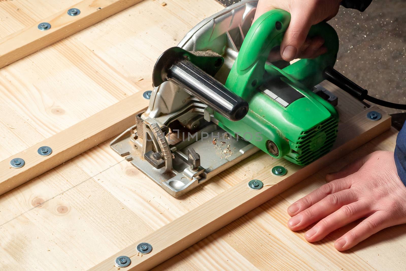 Male hands sawing boards with a circular saw by galsand