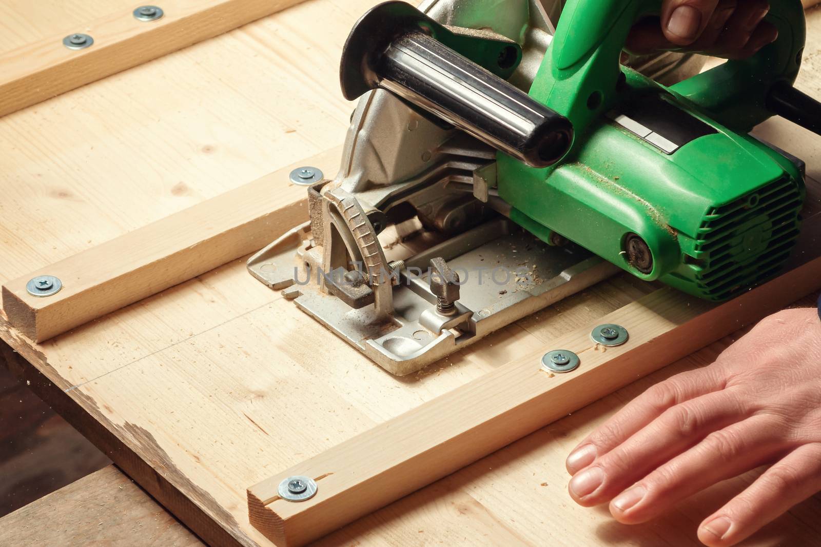 Male hands sawing boards with a circular saw by galsand