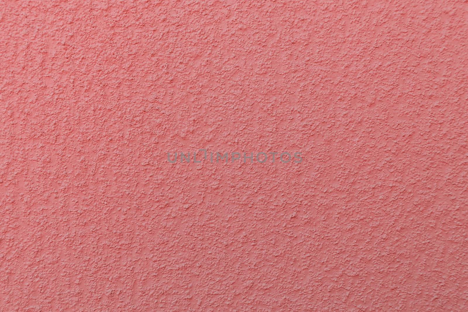 surface of the plastered wall painted in coral color-trendy color of 2019 year by galsand