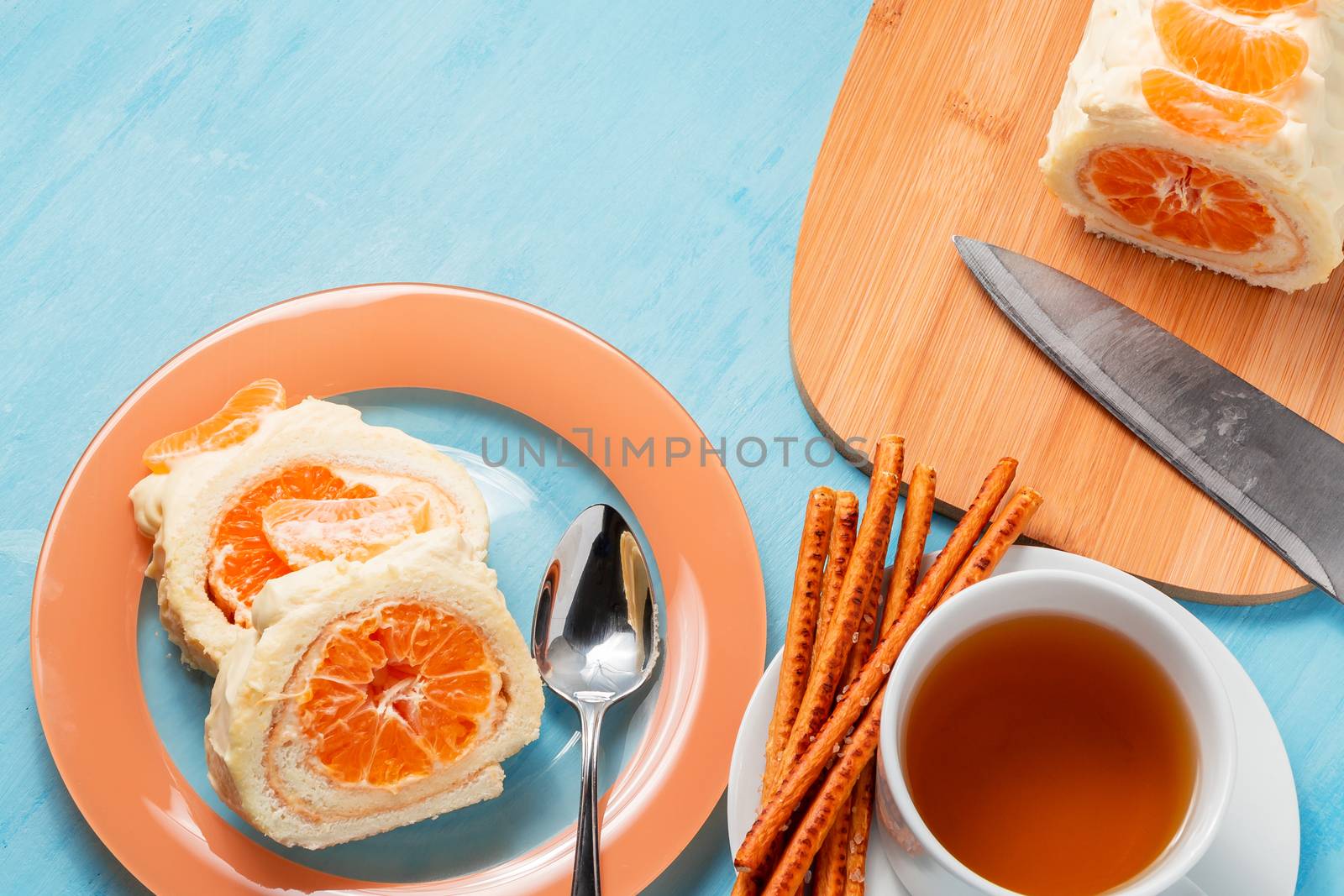 Sweet roll with whipped cream and tangerine filling and a cup of tea.