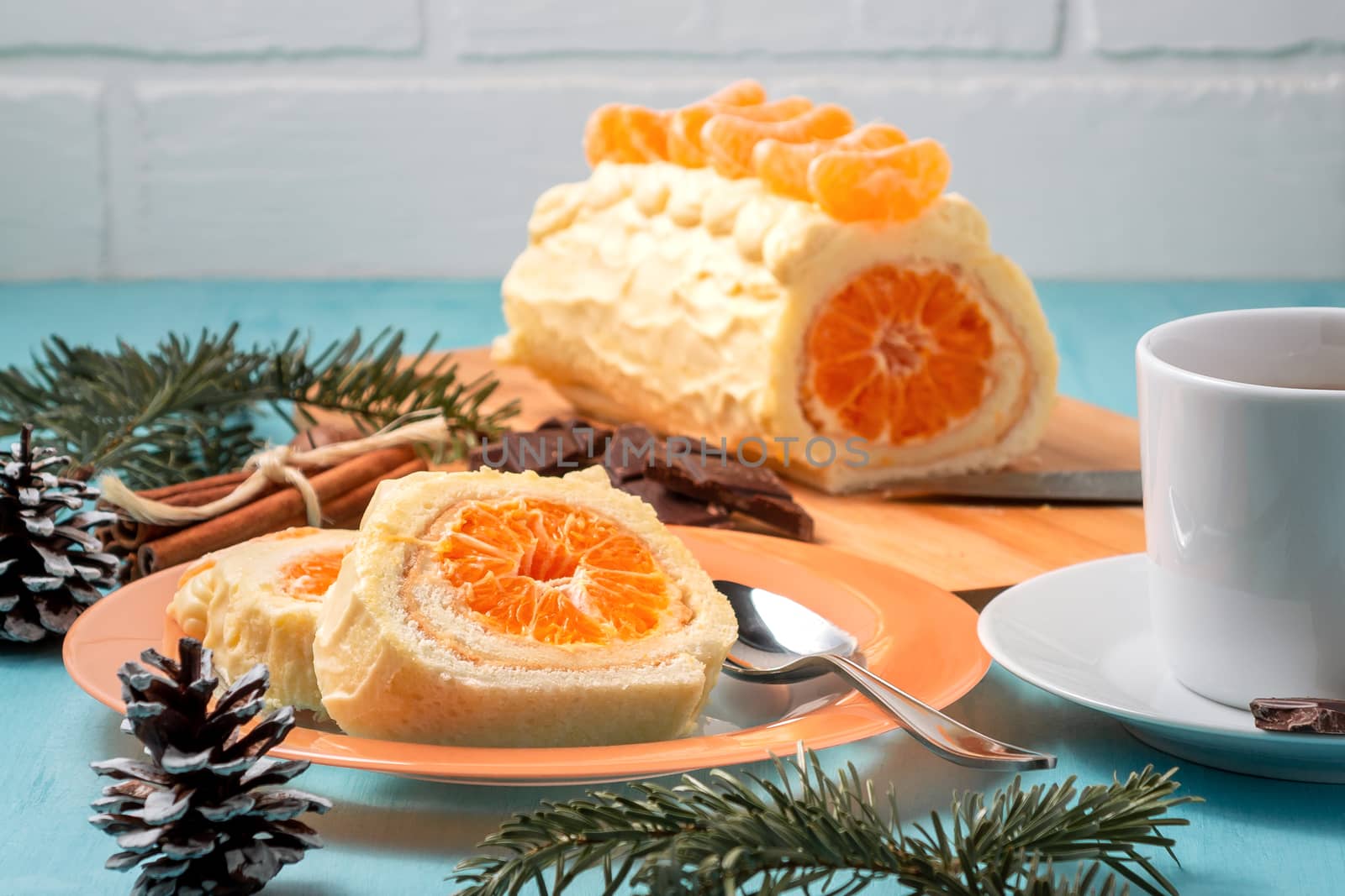 Sweet roll with whipped cream and tangerine filling and Christmas decorations.