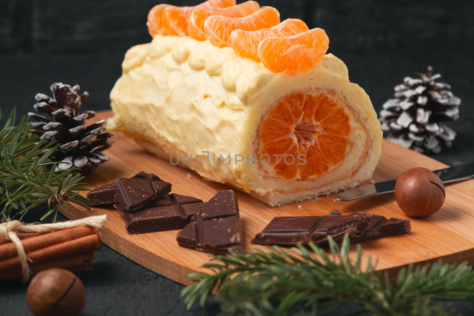 Sweet roll with whipped cream and tangerine filling and Christmas decorations by galsand