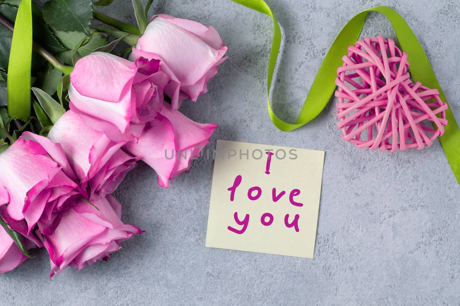 bouquet of pink roses, a heart and a note with the inscription I love you on the table-the concept of love and care by galsand