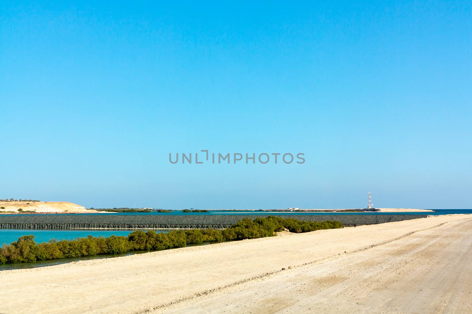 road along the sandy bulk dam in Abu Dhabi.