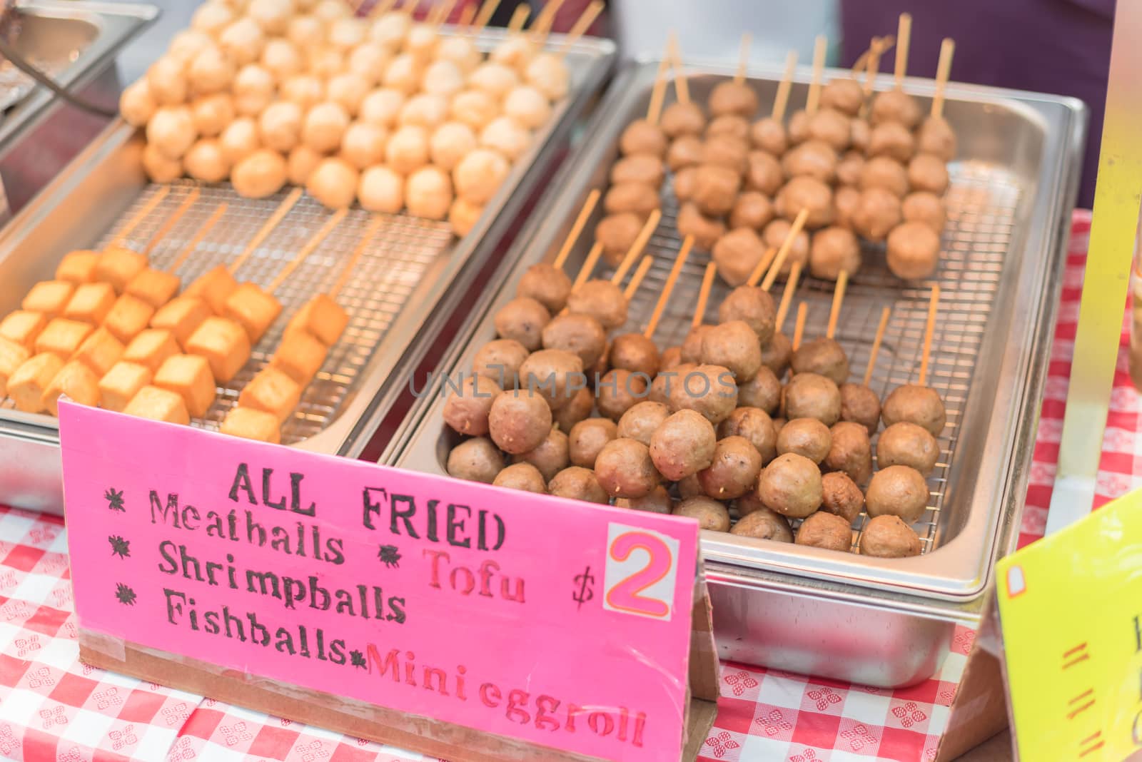All fried, close-up, selective focus of skewers with fried meatballs, shrimp balls, fish balls, mini eggroll and tofu