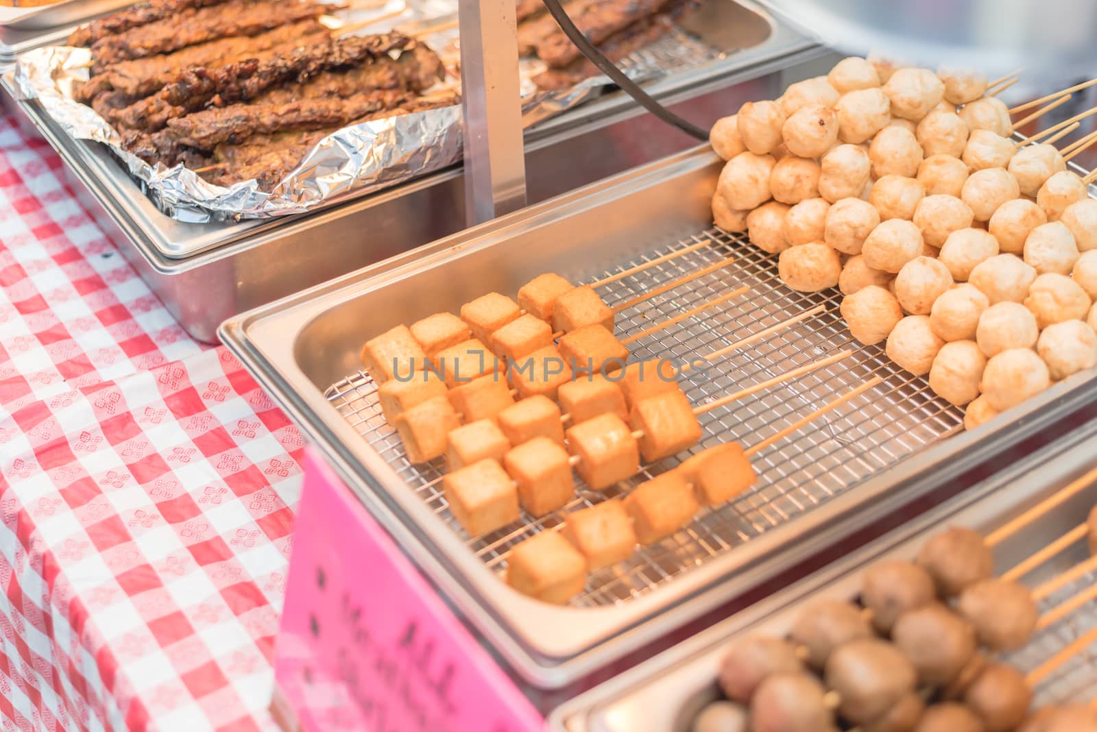 All fried, close-up, selective focus of skewers with fried meatballs, shrimp balls, fish balls, mini eggroll and tofu