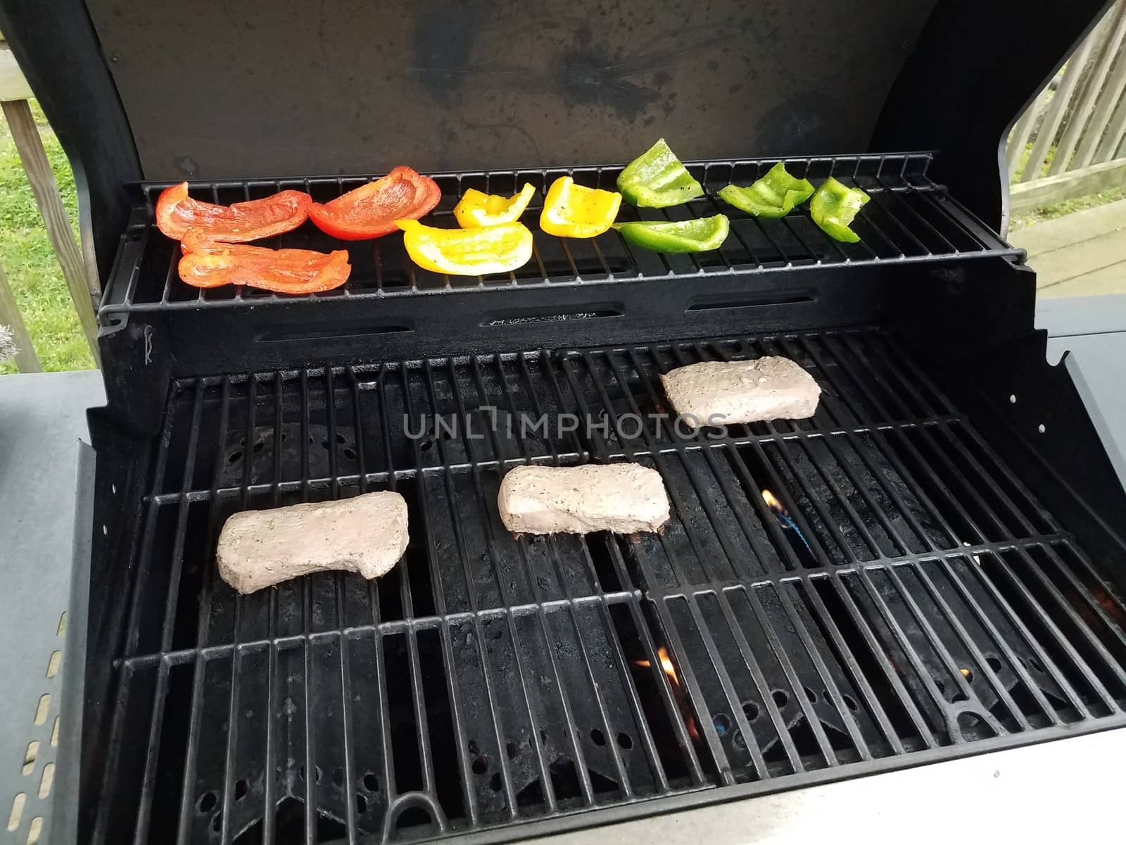 steak and bell peppers cooking on a barbecue grill