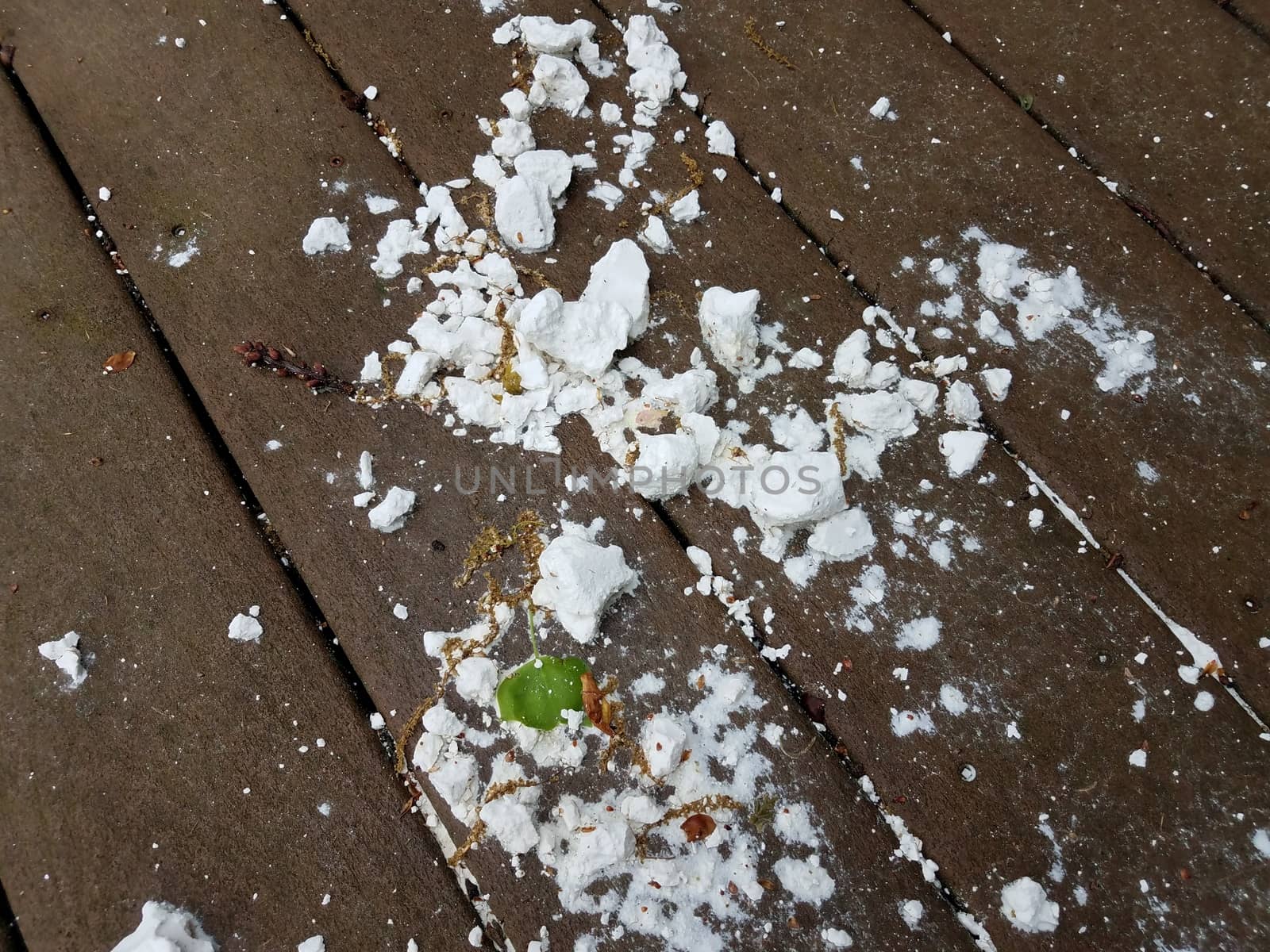 wet white chalk substance on brown wood deck or ground