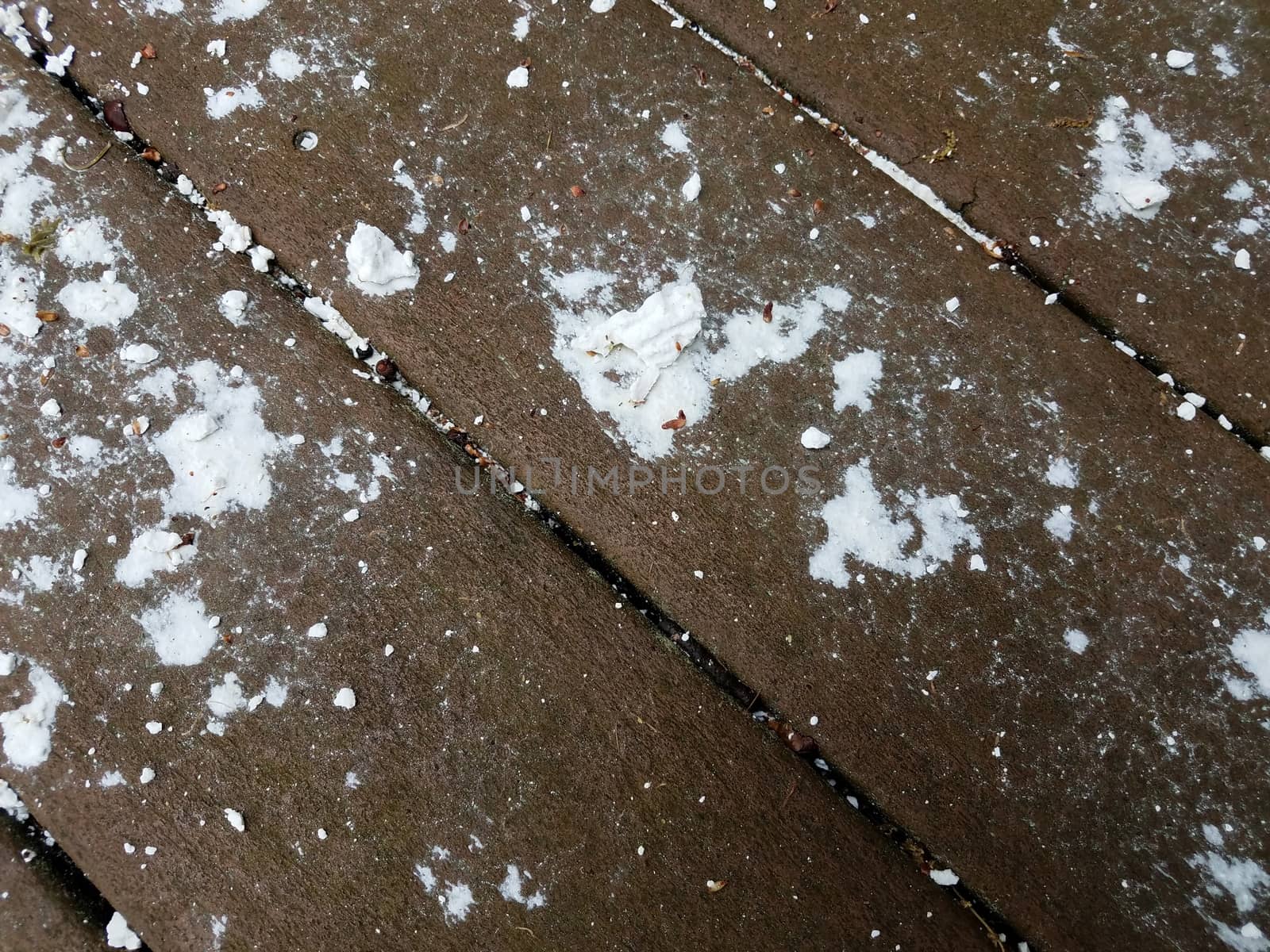 wet white chalk substance on brown wood deck or ground