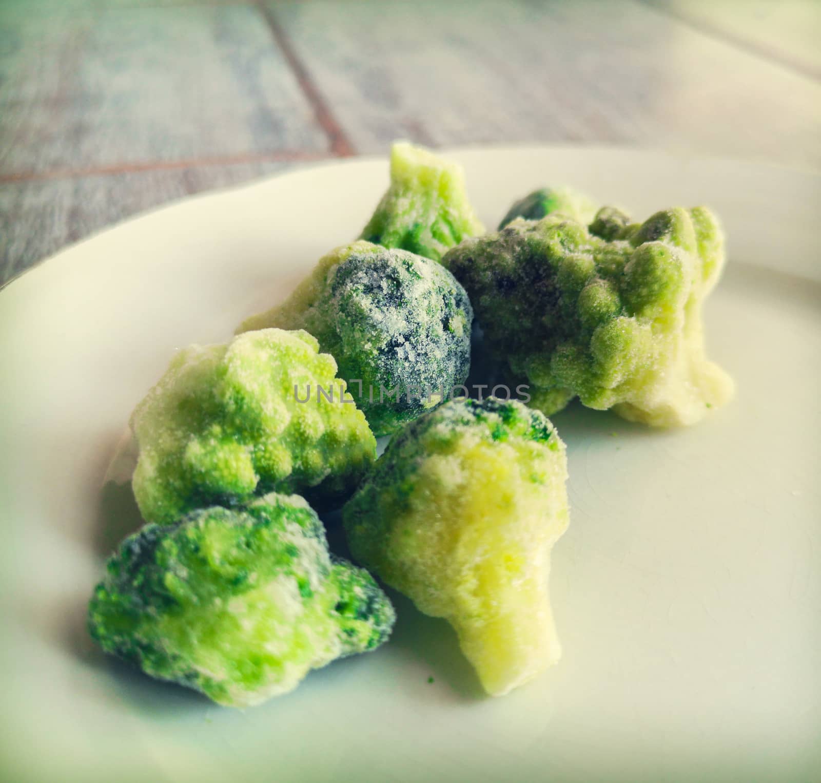 frosted broccoli frozen veggies icing in freezer fridge .