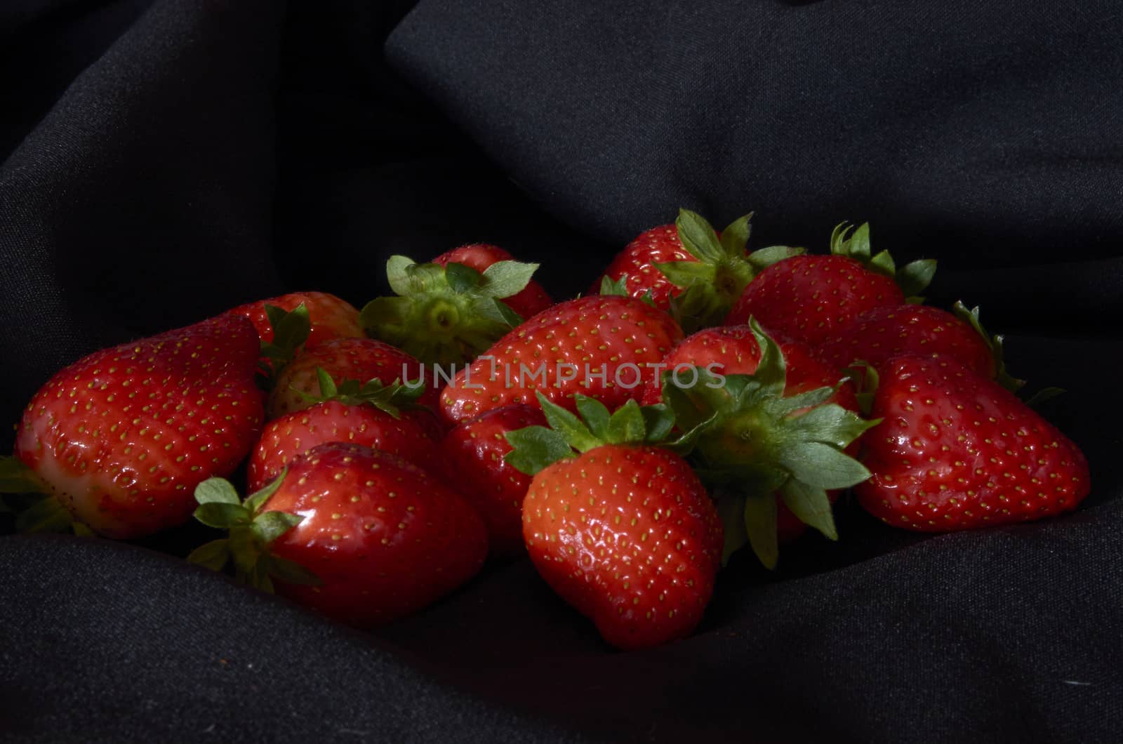 Strawberries on black background, long exposure natural light