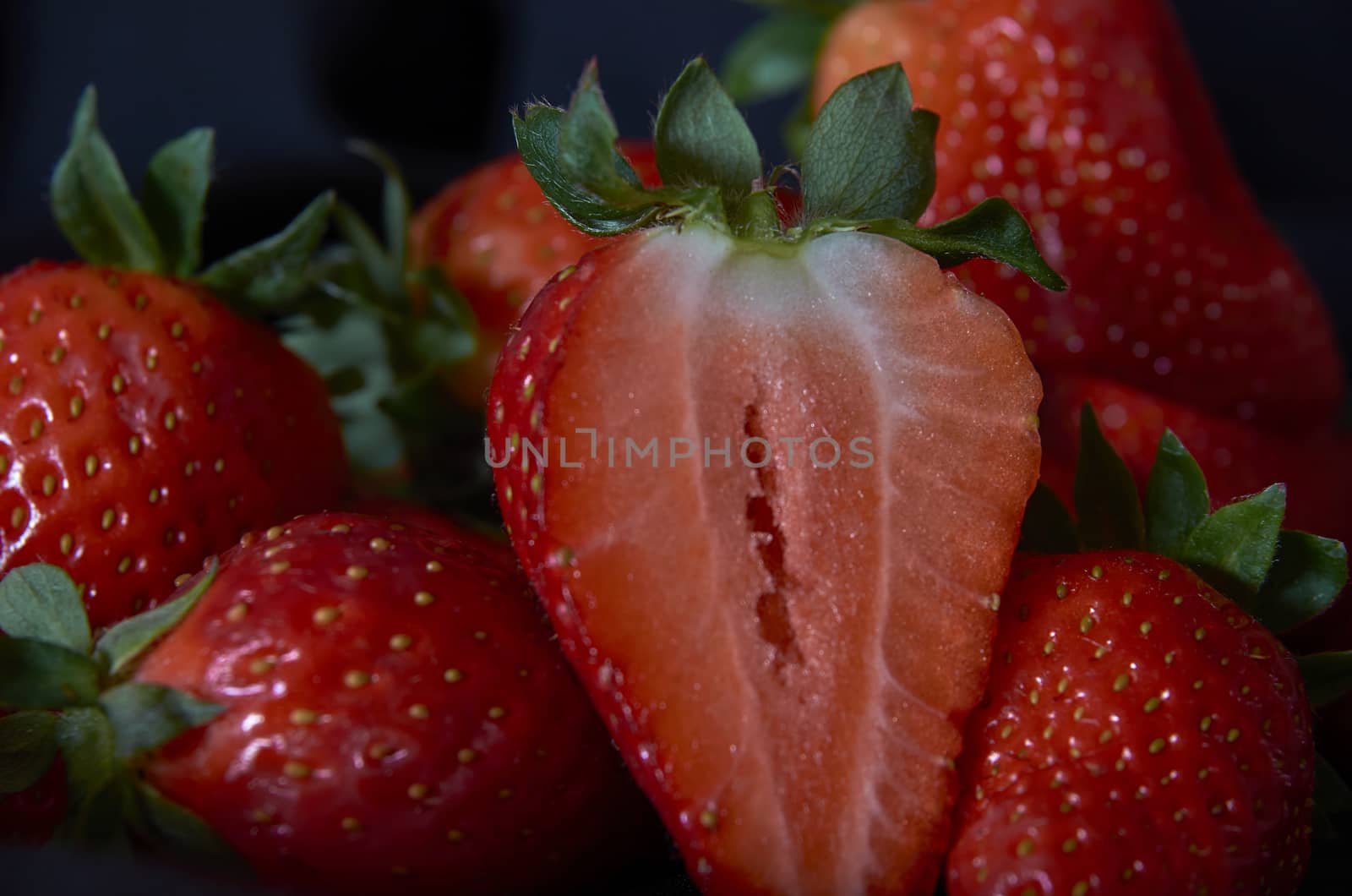 Strawberries on black background, long exposure natural light