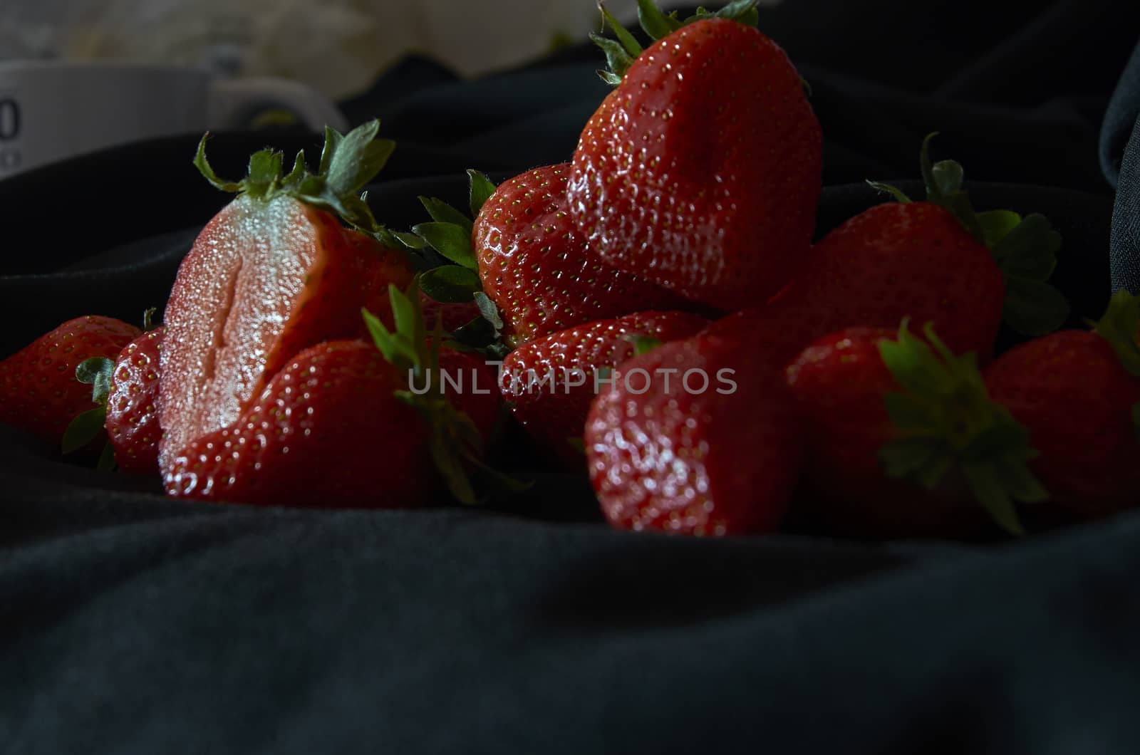 Strawberries on black background, long exposure natural light