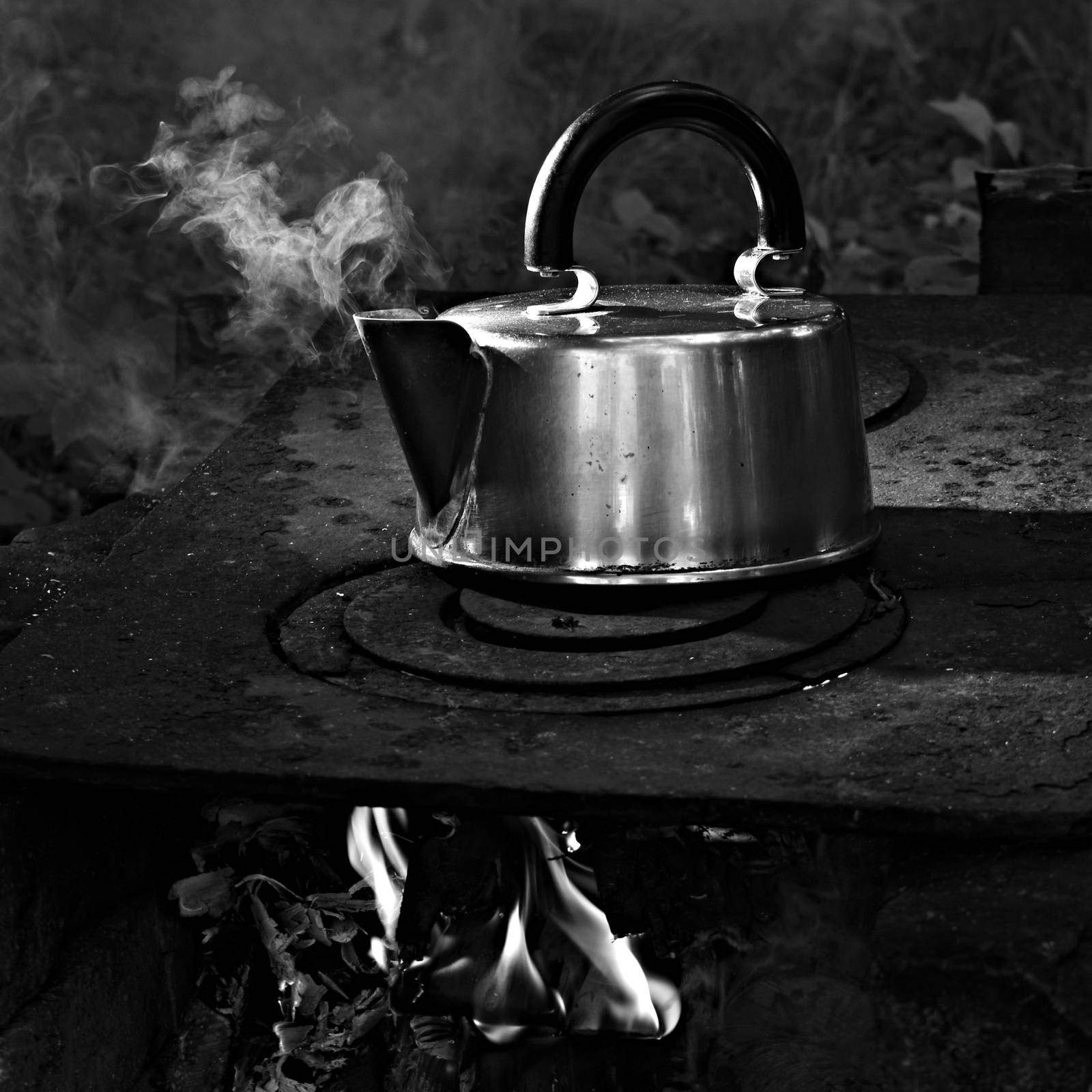 kettle with boiling water on the garden stove, black and white image