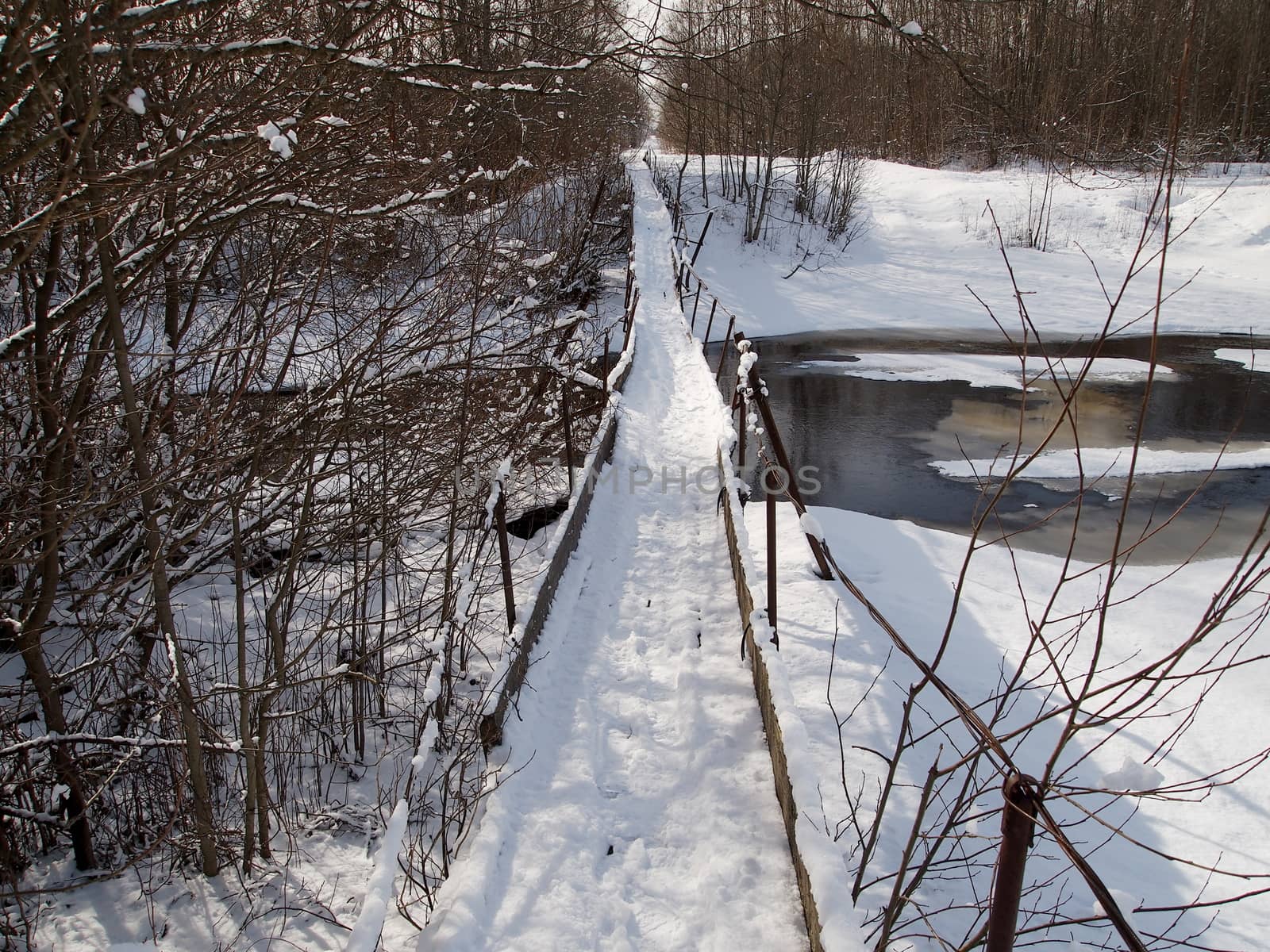 winter, a suspension bridge over a small river