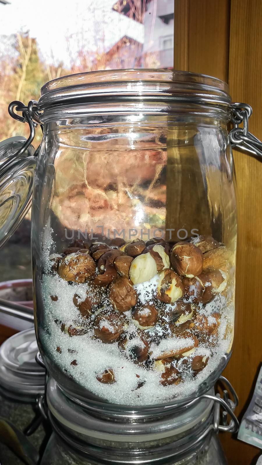 Many hazelnuts and sugar in a big glass by sandra_fotodesign