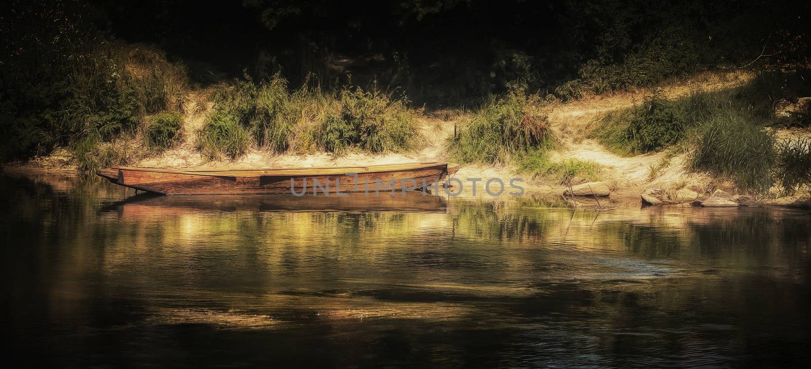 A wooden boat leaving by the river