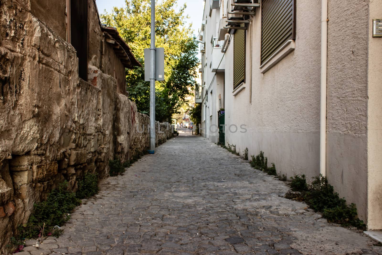 a wide shoot of urban street with stone floors and old vintage buildings. photo has taken from foca/izmir.