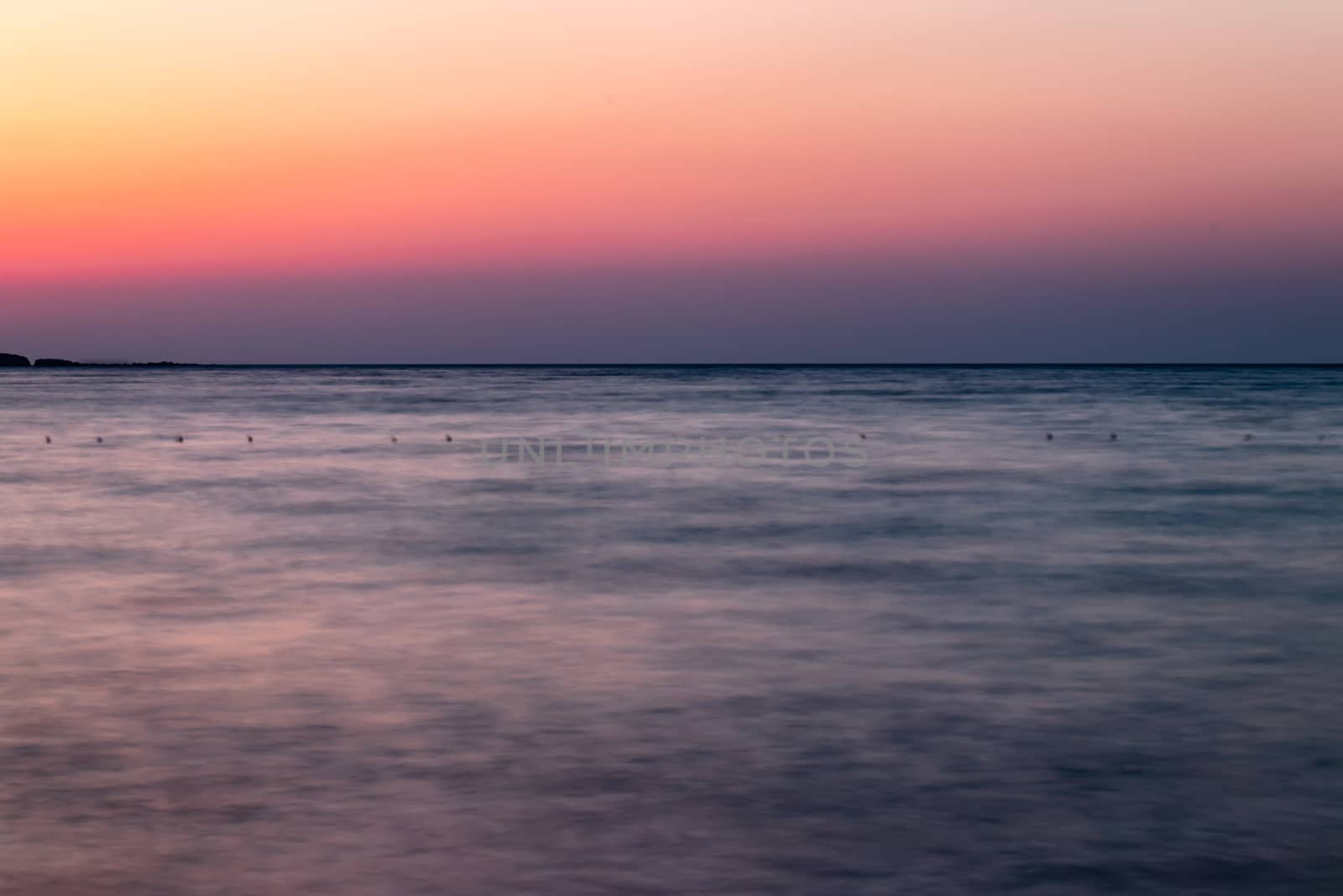 a long exposure wide landscape shoot of sea at sunset with good colors very smooth shoot. photo has taken at izmir/turkey.