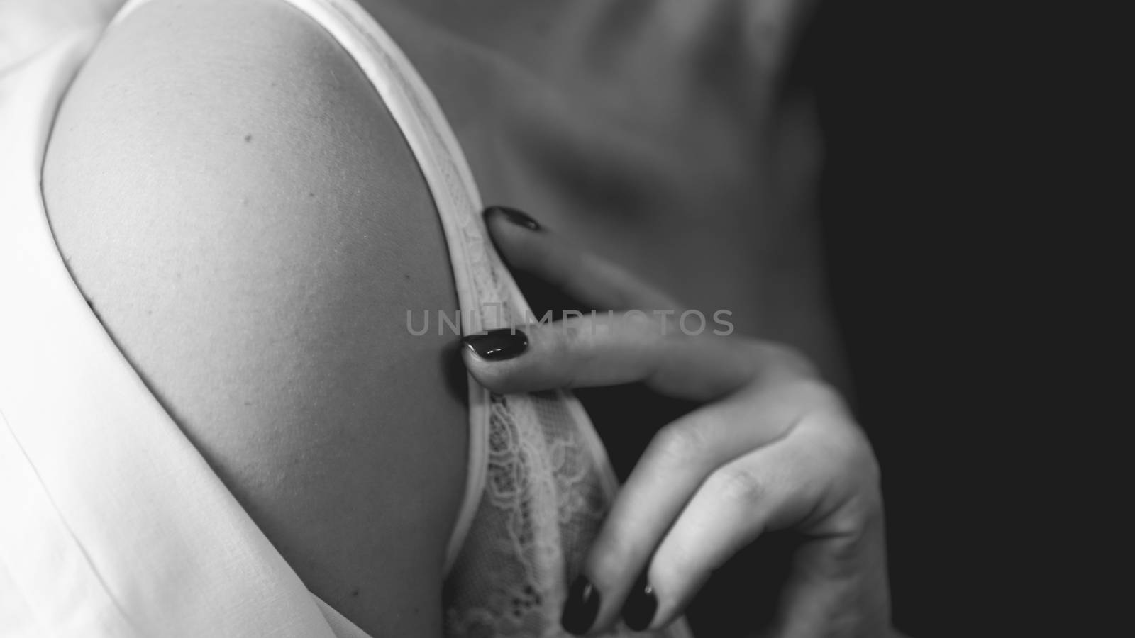 Hands of woman undressing white bra. Hands of woman undressing brassiere. Close-up nude photo
