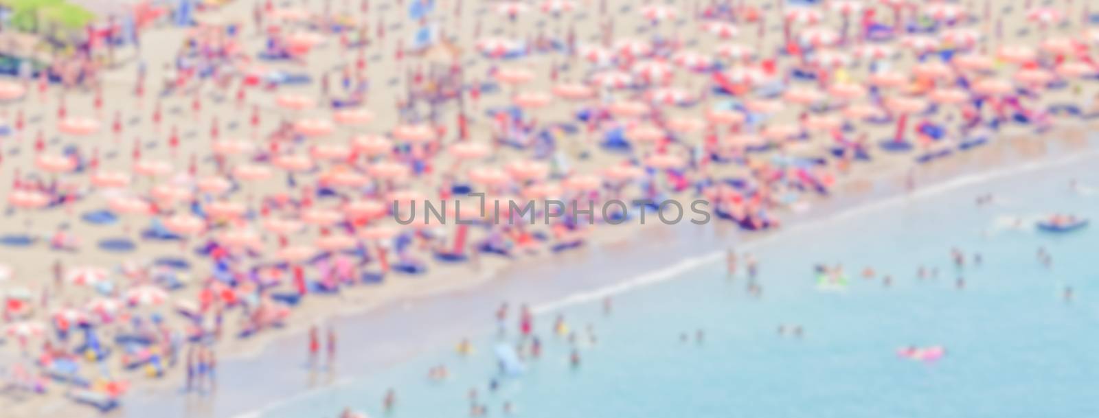 Defocused background with a crowded beach in  Italy by marcorubino