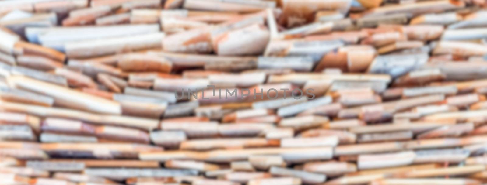 Defocused background with stack of wood. Intentionally blurred post production for bokeh effect