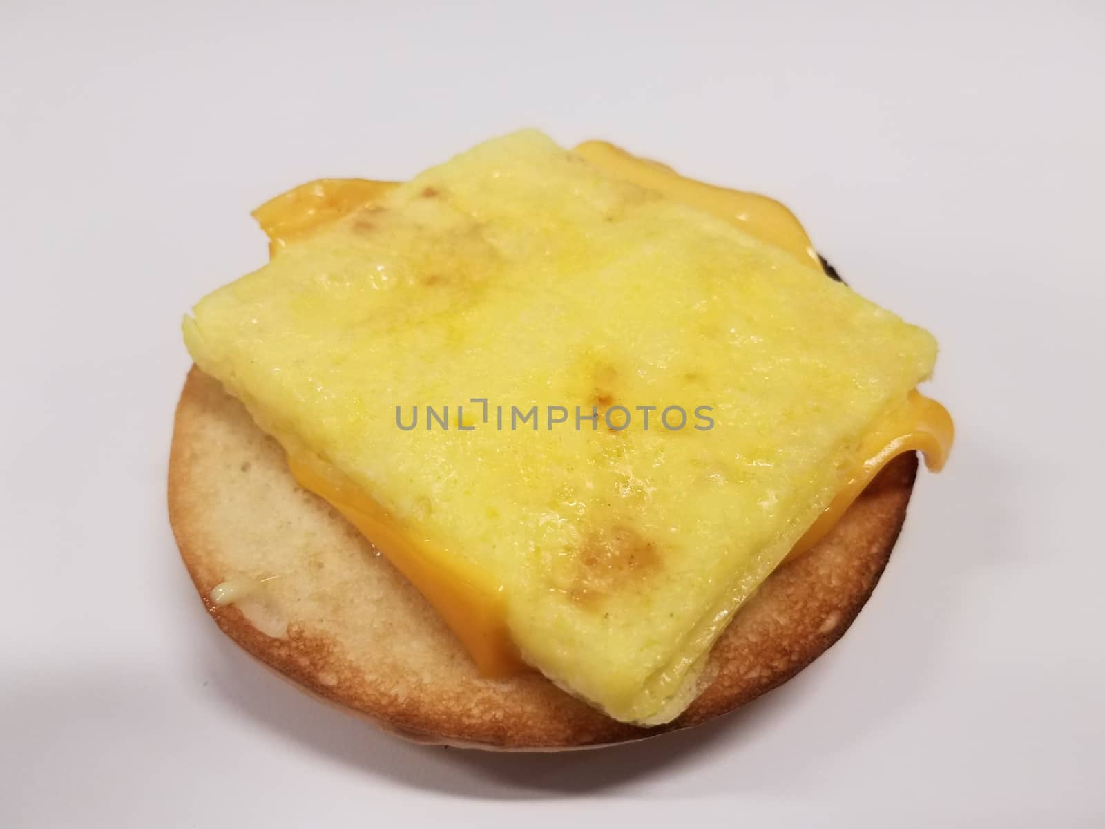 sandwich on white desk with bun, egg, and cheese