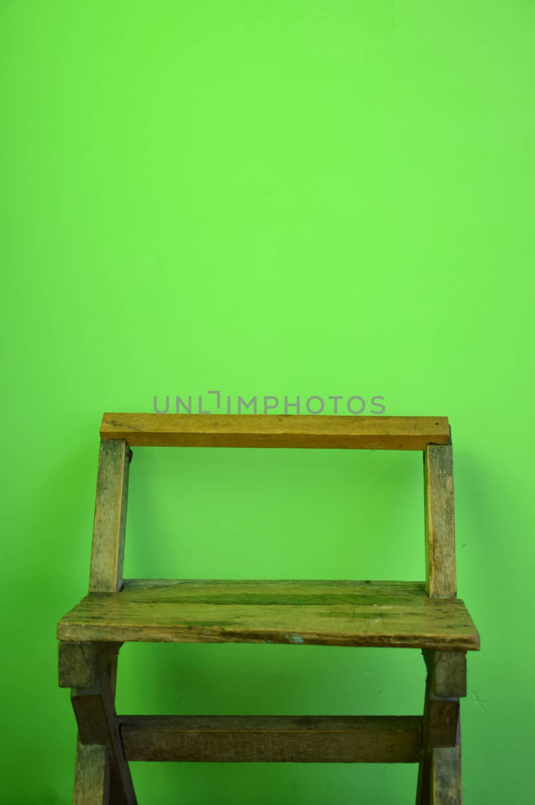 old used wooden chairs on the green wall