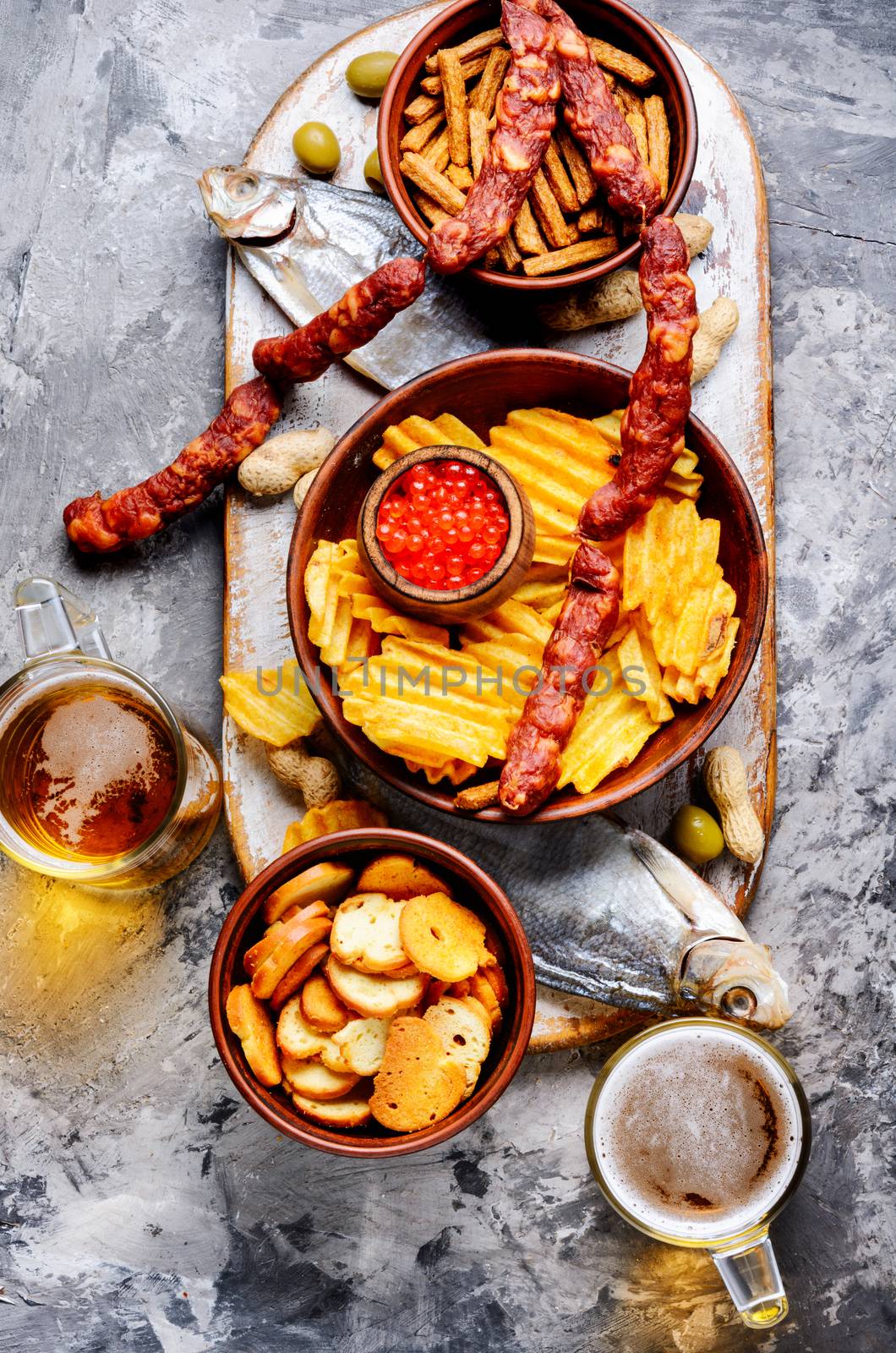 Beer and snacks.Chips, fish, beer sausages on the table