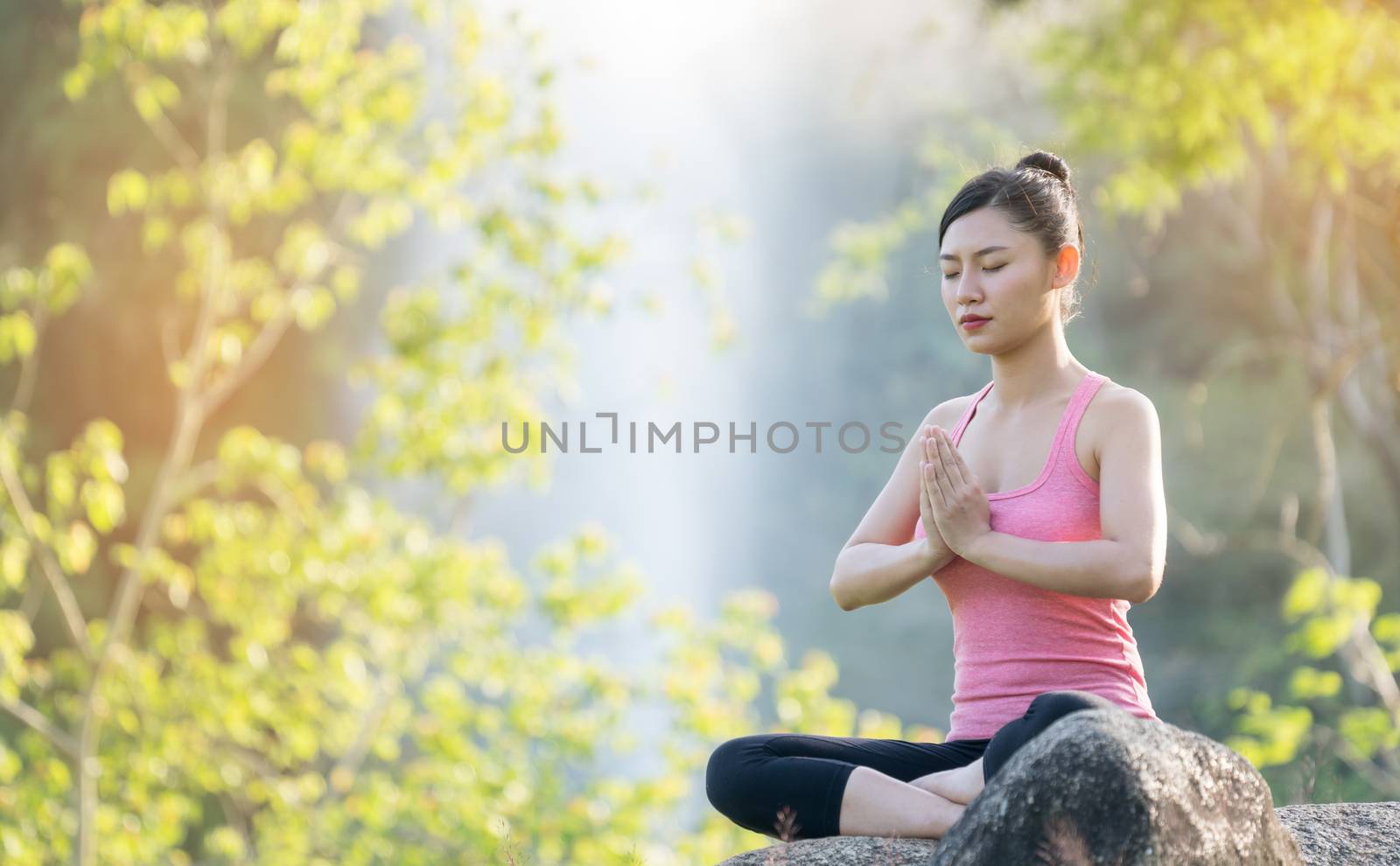 young beautiful asian woman practicing yoga  in the garden