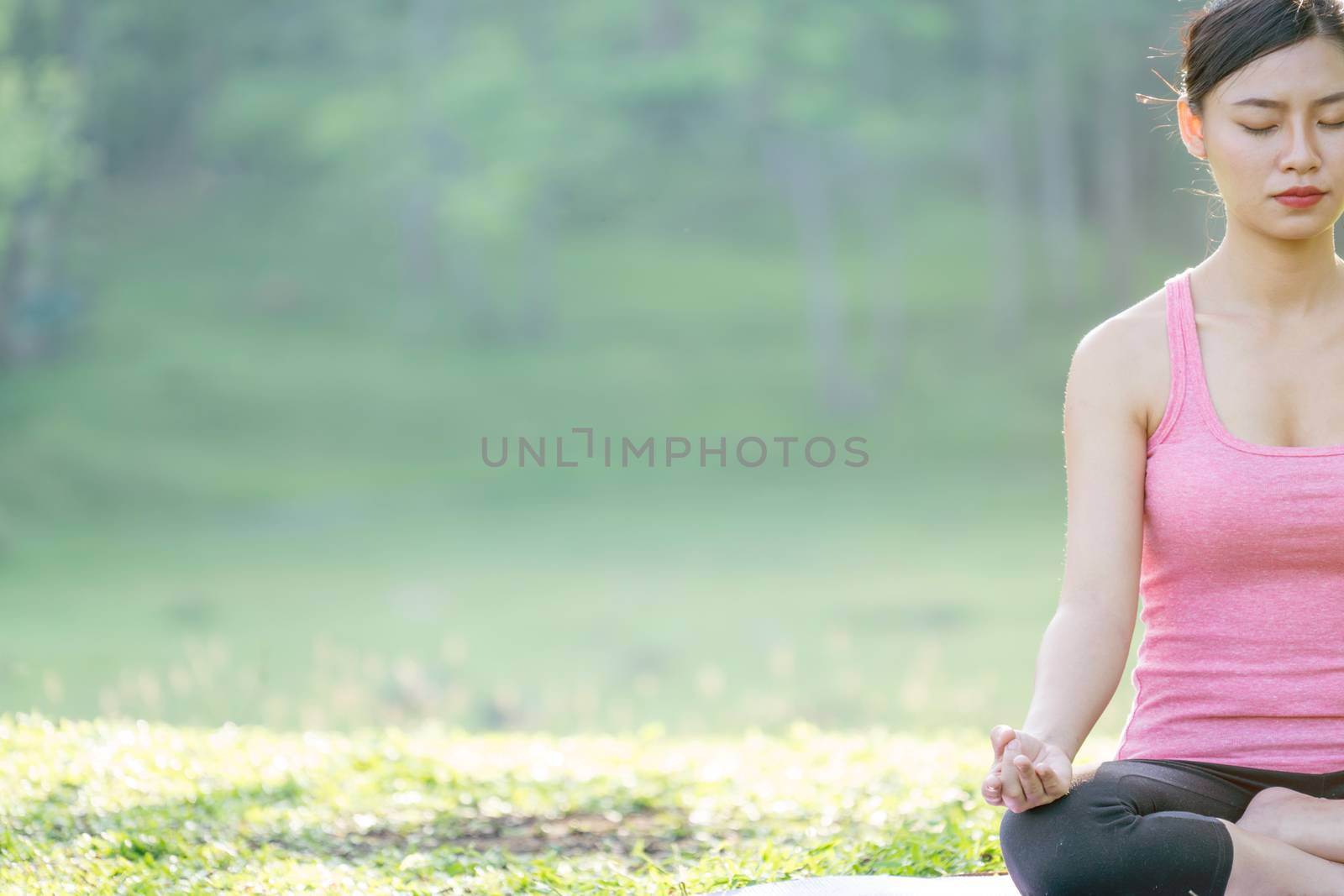 young beautiful asian woman practicing yoga  in the garden