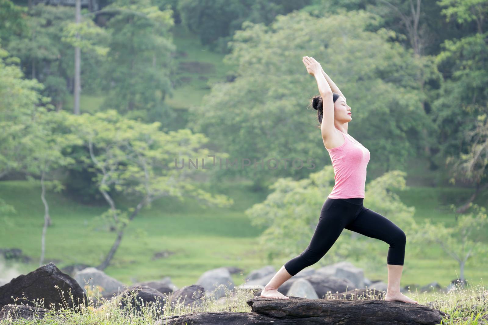 young beautiful asian woman practicing yoga  in the garden