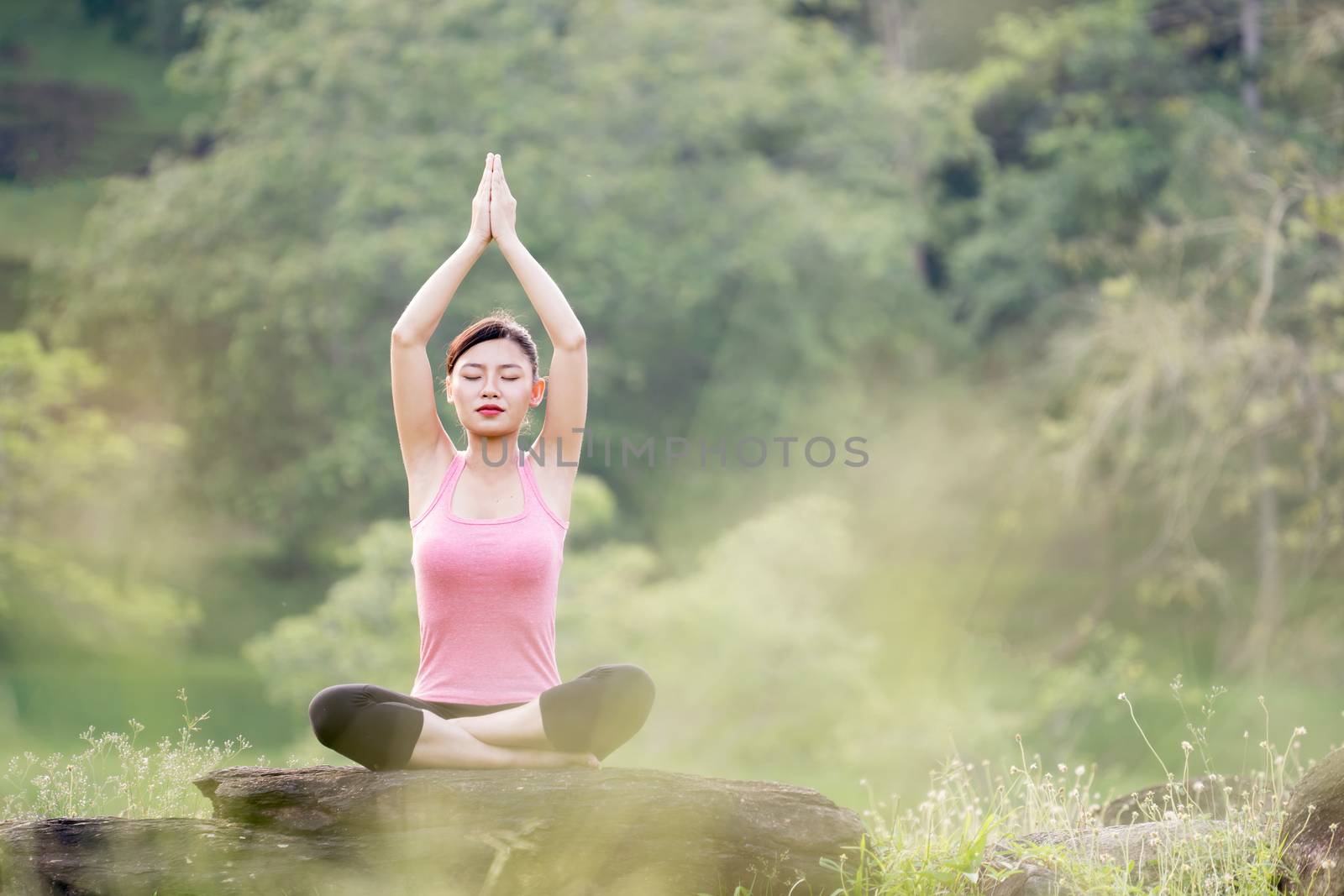 young beautiful asian woman practicing yoga  in the garden