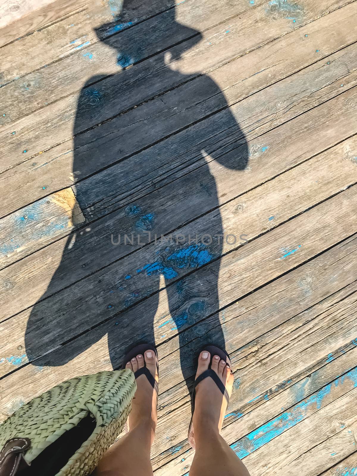 Top view, photo of bare feet and a pair of shadows on a wooden o by Tanacha