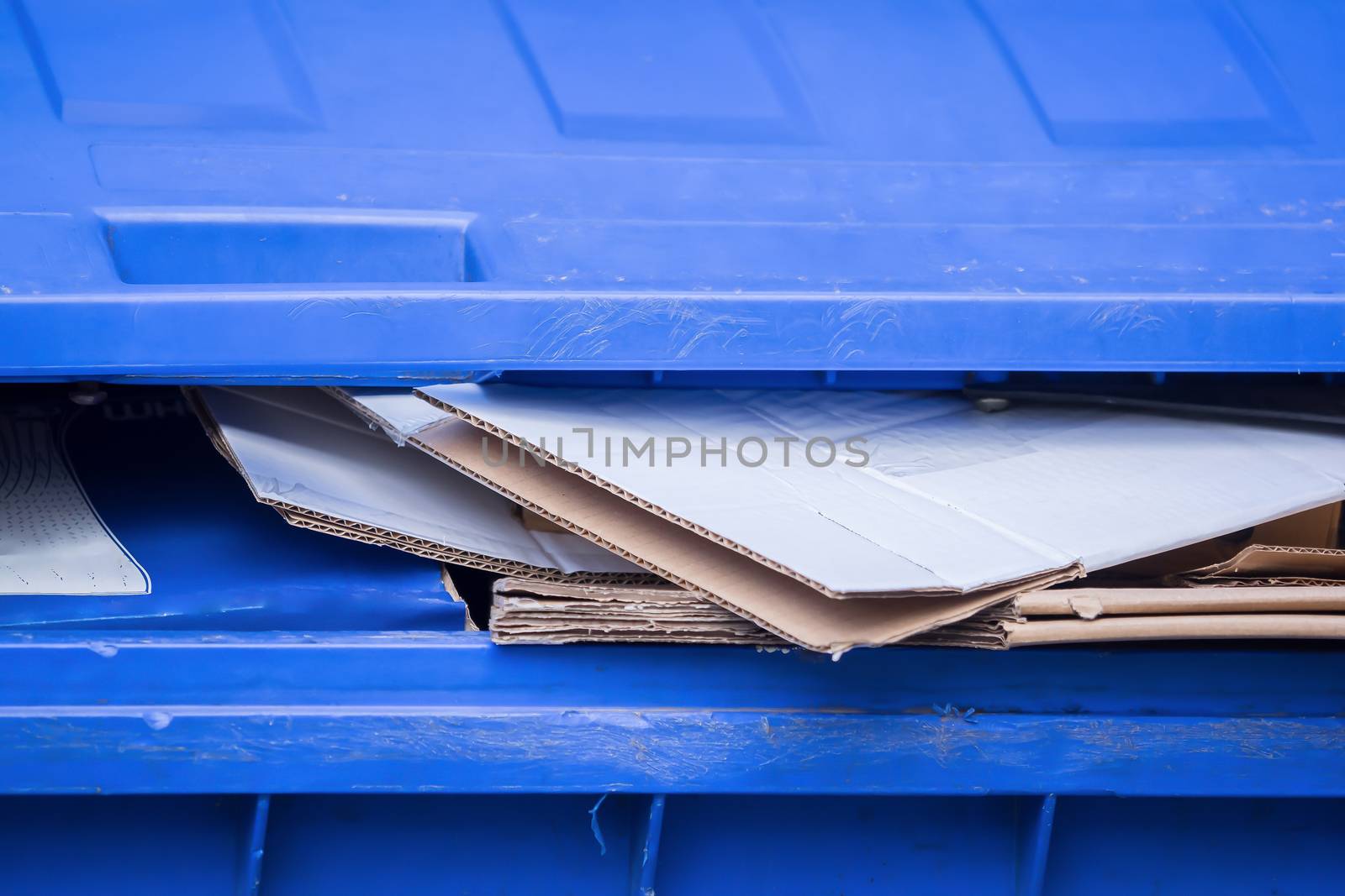 A blue bin for old paper and cardboard boxes