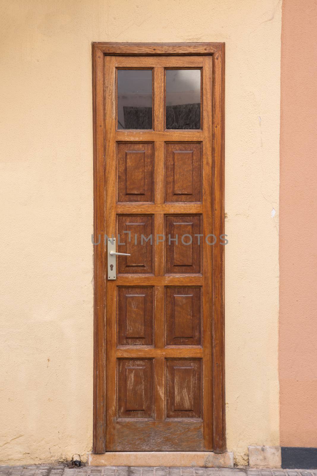 A wooden door with small windows above