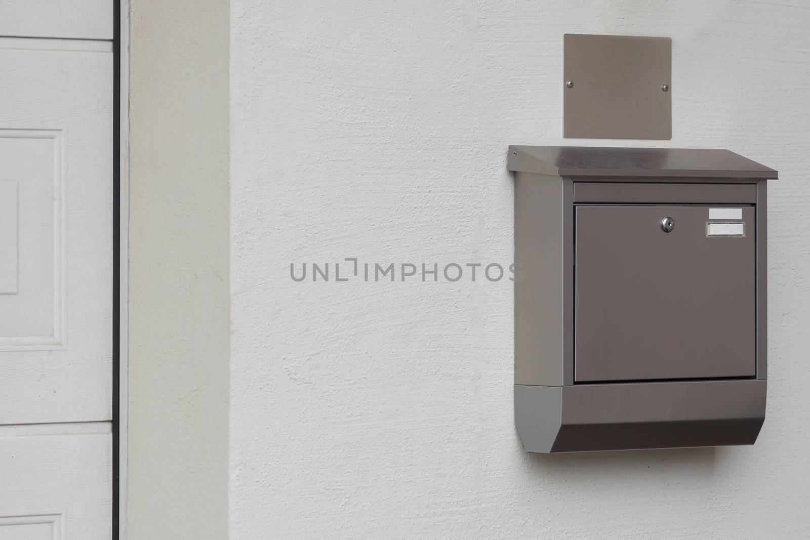 A silver mailbox on the wall by sandra_fotodesign