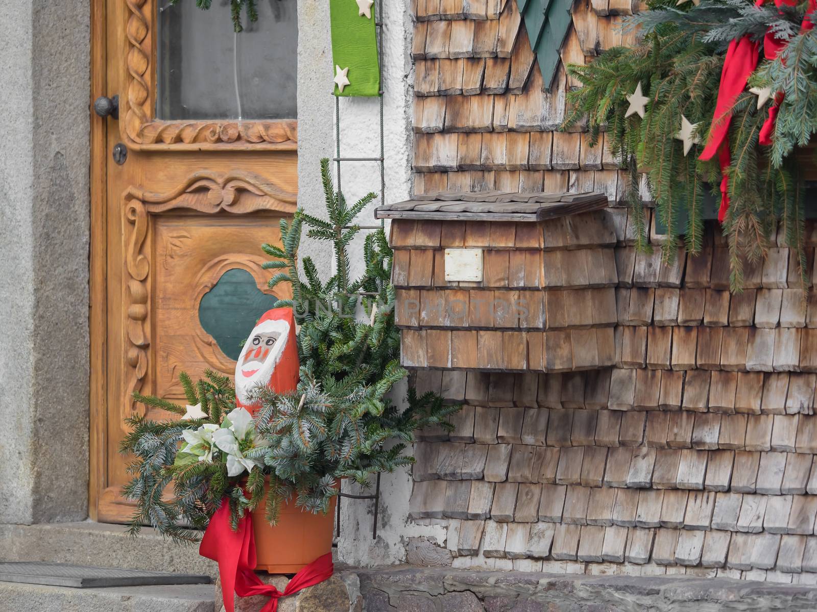 A mailbox on the wall with wooden shingles