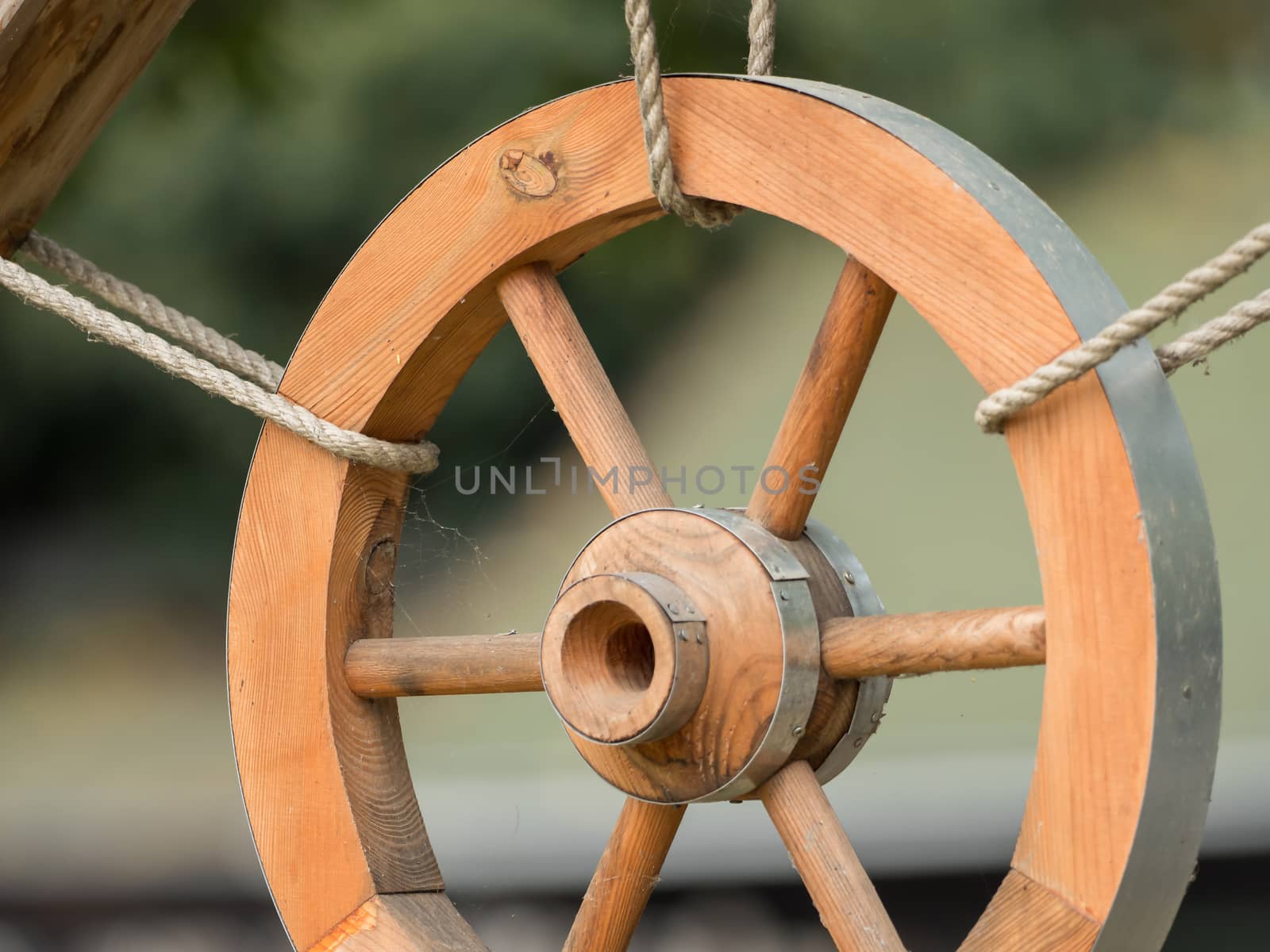 A wooden wheel hangs out as a decoration by sandra_fotodesign