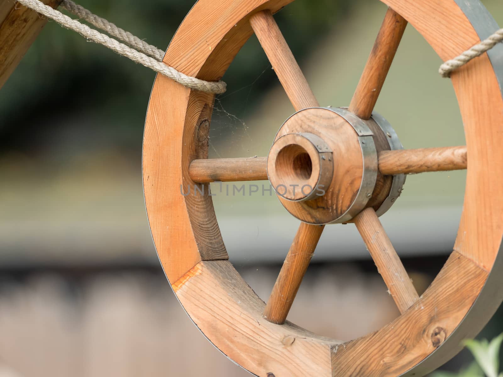 A wooden wheel hangs out as a decoration by sandra_fotodesign