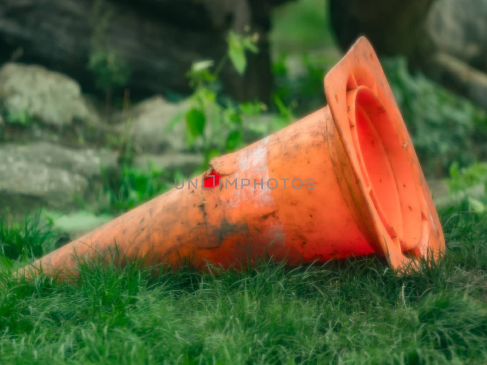 An orange traffic cone in the grass